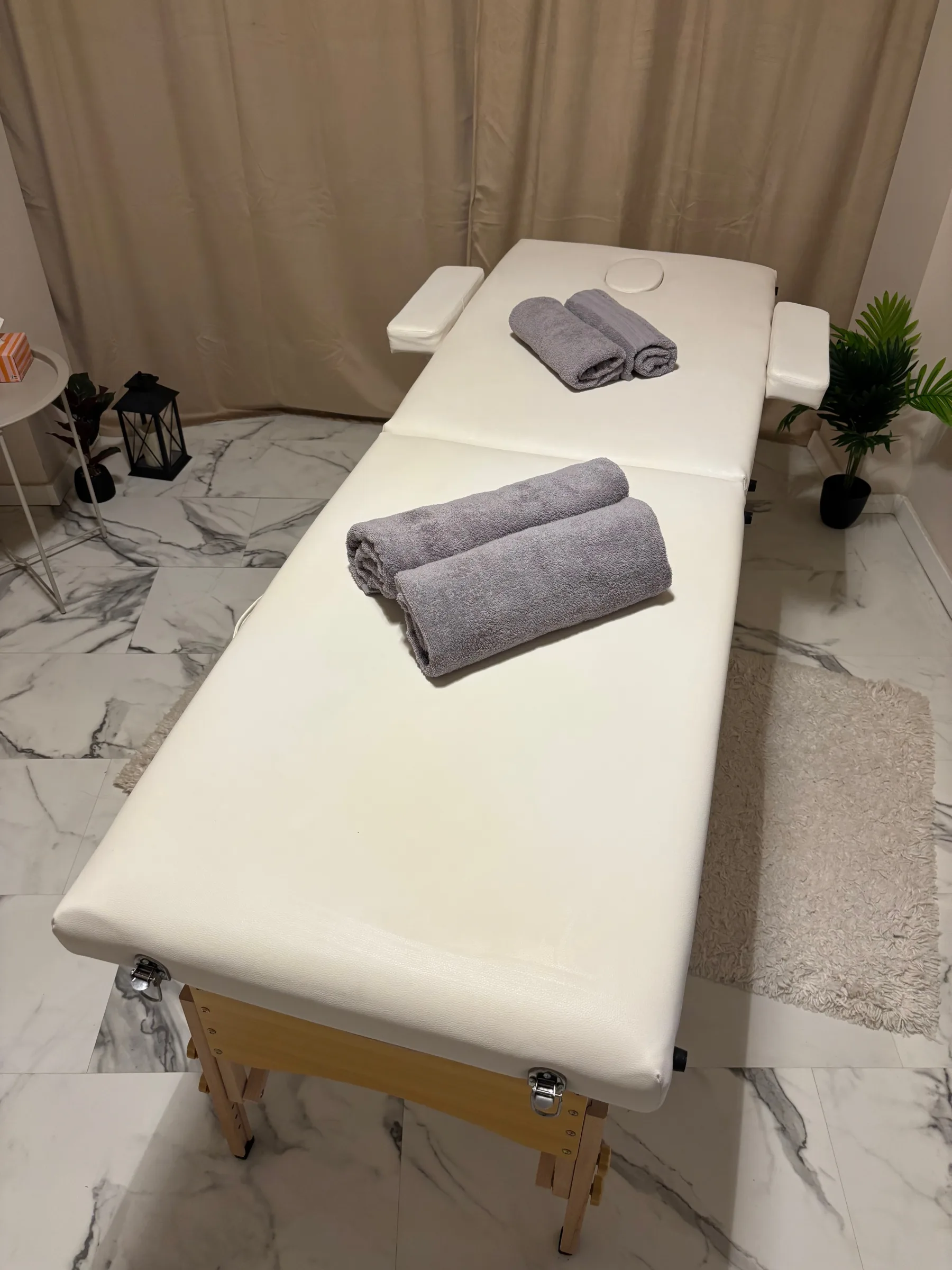 Masszázságy törölközőkkel és növénnyel